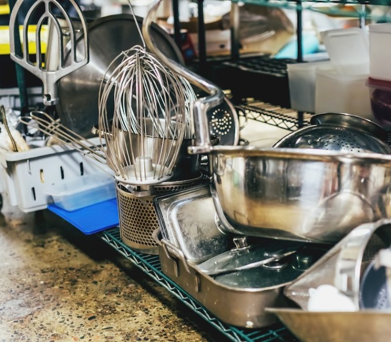 Kitchen utensils on shelves in an industrial kitchen.